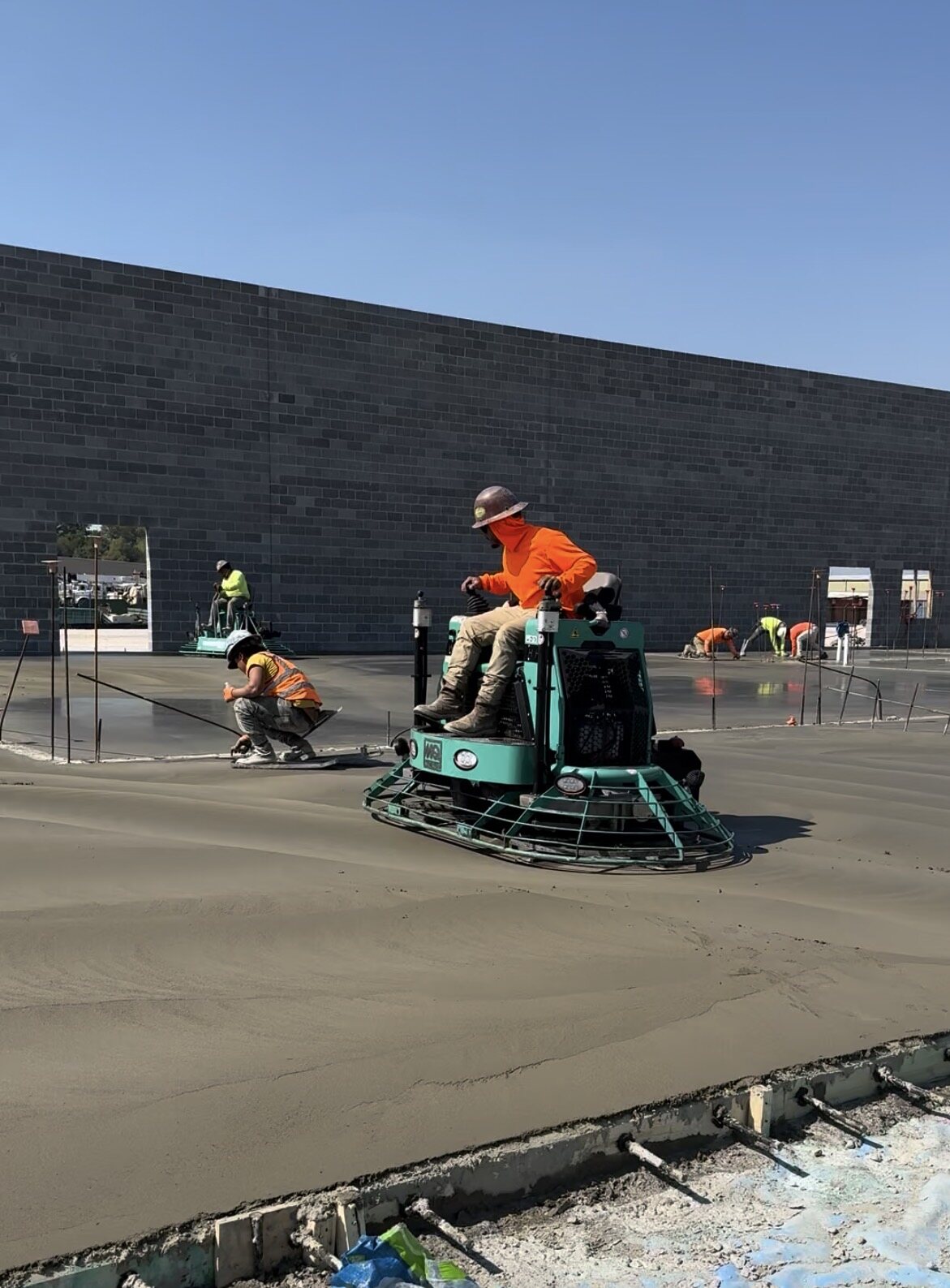 Ride-on power trowels finishing a large warehouse slab