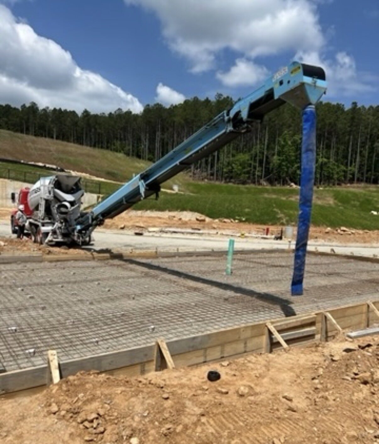 Telebelt conveyor placing concrete from a mixer truck over a reinforced slab