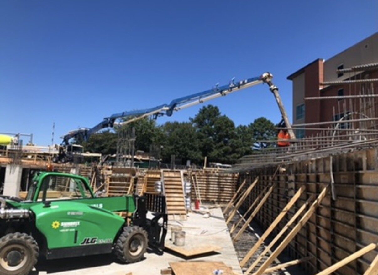 Telehandler and pump boom serving structural wall formwork