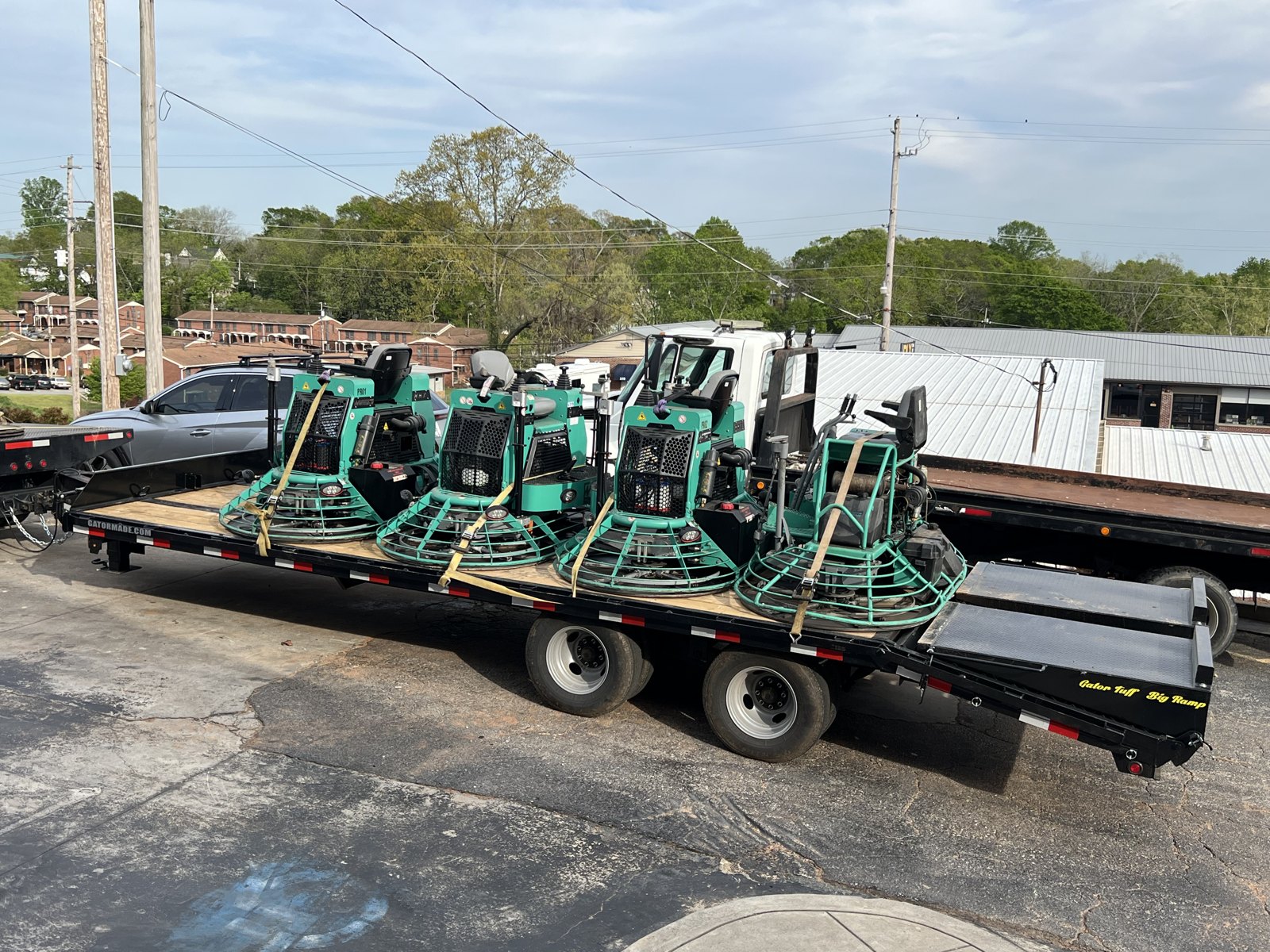 Gooseneck trailer loaded with ride-on power trowels ready for delivery